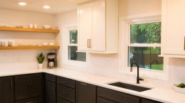 Two-toned kitchen cabinet design with white kitchen cabinets sitting above and modern black cabinets sitting below the white countertop.