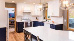 Modern kitchen with white wall kitchen cabinets and under-the-counter dark blue kitchen cabinets.